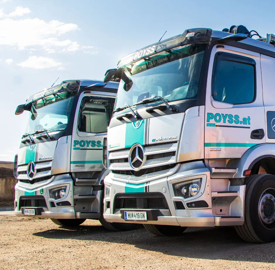 Zwei LKW von Poyss mit Firmenlogo nebeneinander